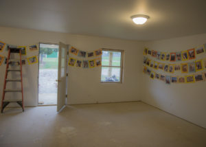 Photos hang in JCHC's nearly finished transitional home, showing progress during the building process.