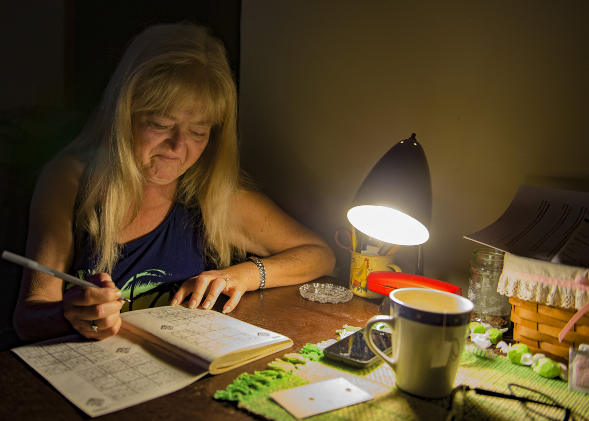 Sheliah Price works on a Sudoku puzzle in her transitional home, which she moved into after her mobile home burned down in June.