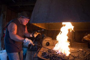 Rob Miller heats a piece of metal in the primary forge of the blacksmith shop in McConnelsville.